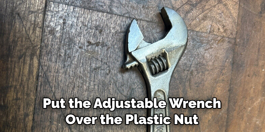 Put the Adjustable Wrench Over the Plastic Nut