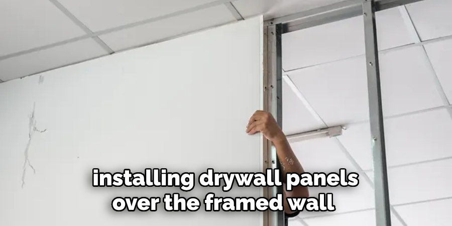 installing drywall panels over the framed wall 