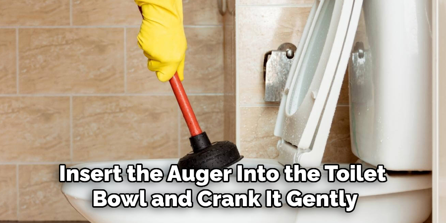 Insert the Auger Into the Toilet Bowl and Crank It Gently