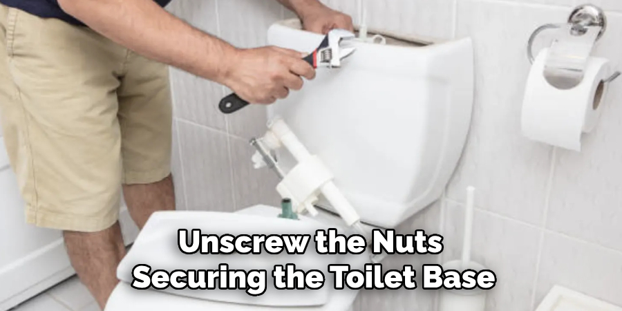 Unscrew the Nuts Securing the Toilet Base