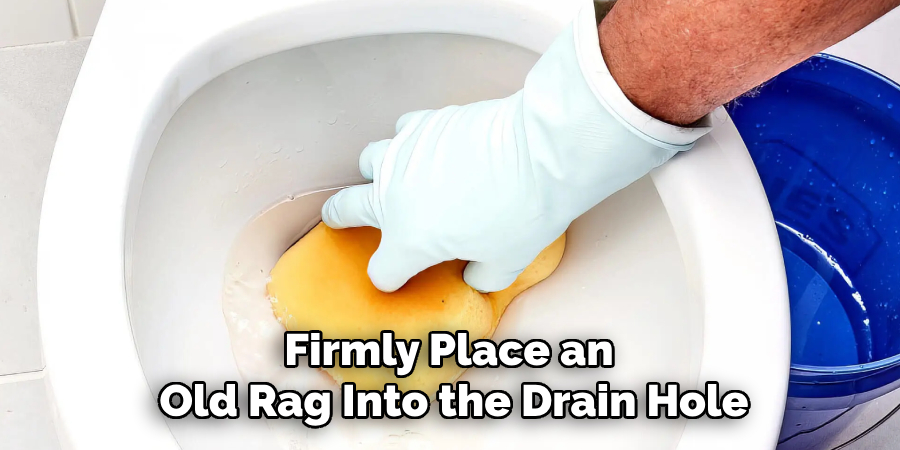 Firmly Place an
Old Rag Into the Drain Hole