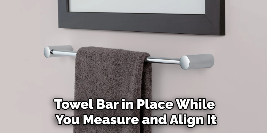 Towel Bar in Place While 
You Measure and Align It