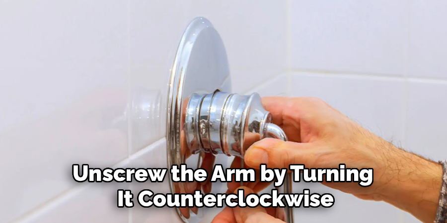 unscrew the arm by turning it counterclockwise